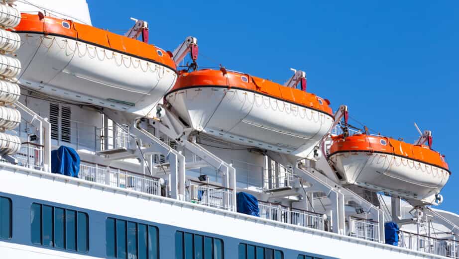 orange and white rescue boats attached to a cruise ship