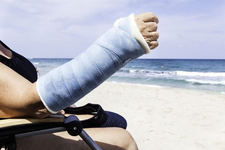 parasailing accident injury woman on the beach with a hand cast 