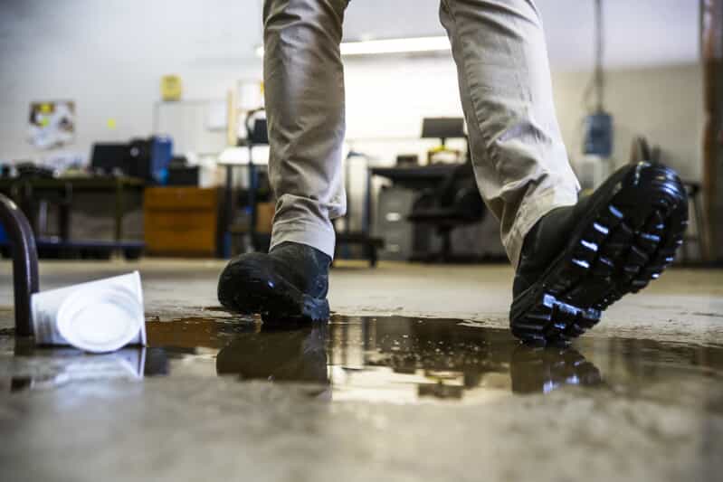 Person in boots slipping on a wet floor