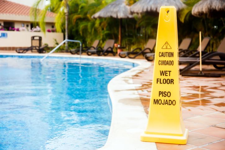caution sign next to a pool